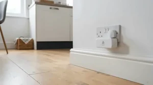 A plug-in mouse repellent for kitchen flooring, positioned near the baseboard to deter pests effectively.